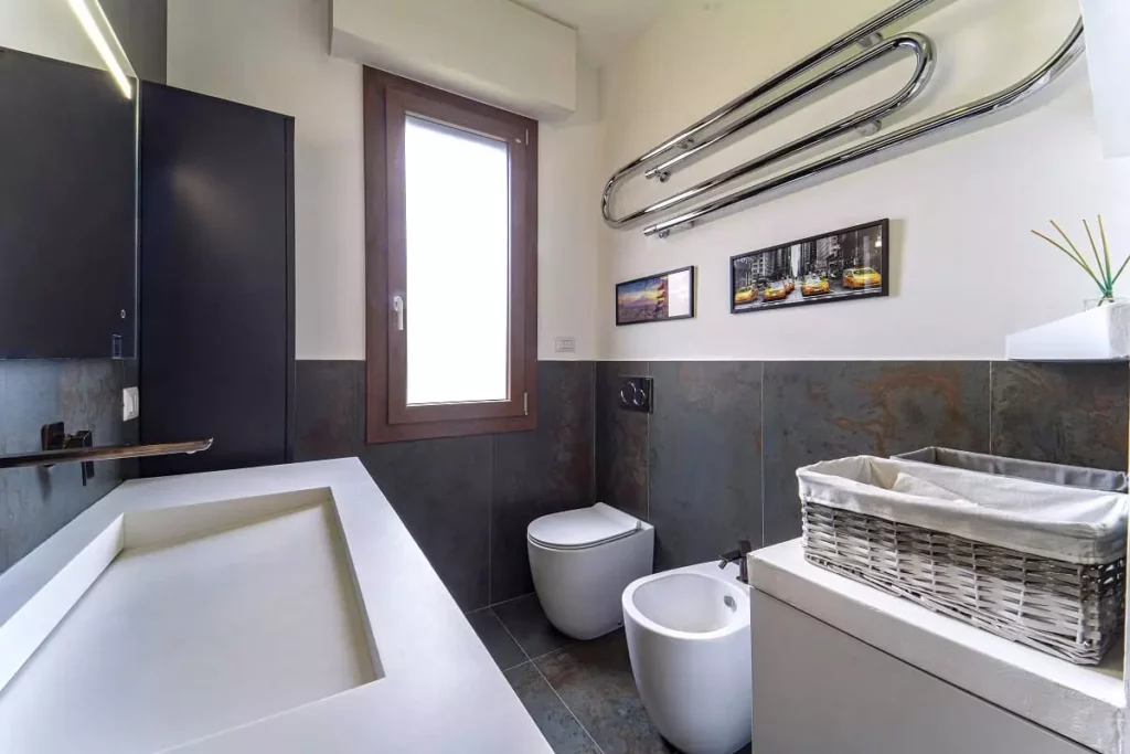 Rivestimento in mattonelle Apavisa effetto ruggine per un bagno moderno dal design industriale. Progetto di studio di architettura di interni