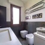 Rivestimento in mattonelle Apavisa effetto ruggine per un bagno moderno dal design industriale. Progetto di studio di architettura di interni