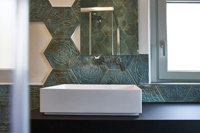 mattonelle rivestimento della ditta apavisa per creare un bagno moderno ma con un tocco retrò. Stile metallico verde acido con lavabo in appoggio su top di legno