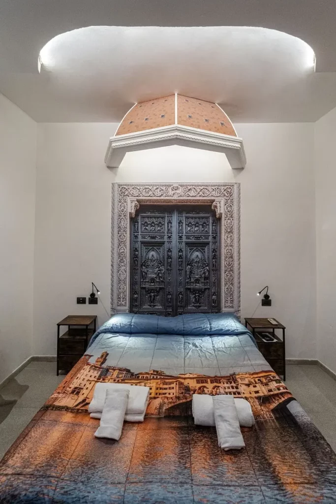 Camera da letto matrimoniale in un B&B di charme a Firenze, dedicata a Filippo Brunelleschi. Cupola artigianale, porta in legno intagliato e arredi in stile rinascimentale. Ideale per coppie in cerca di un'esperienza autentica. Ristrutturazione B&B, progettazione di interni, design d'interni Firenze.